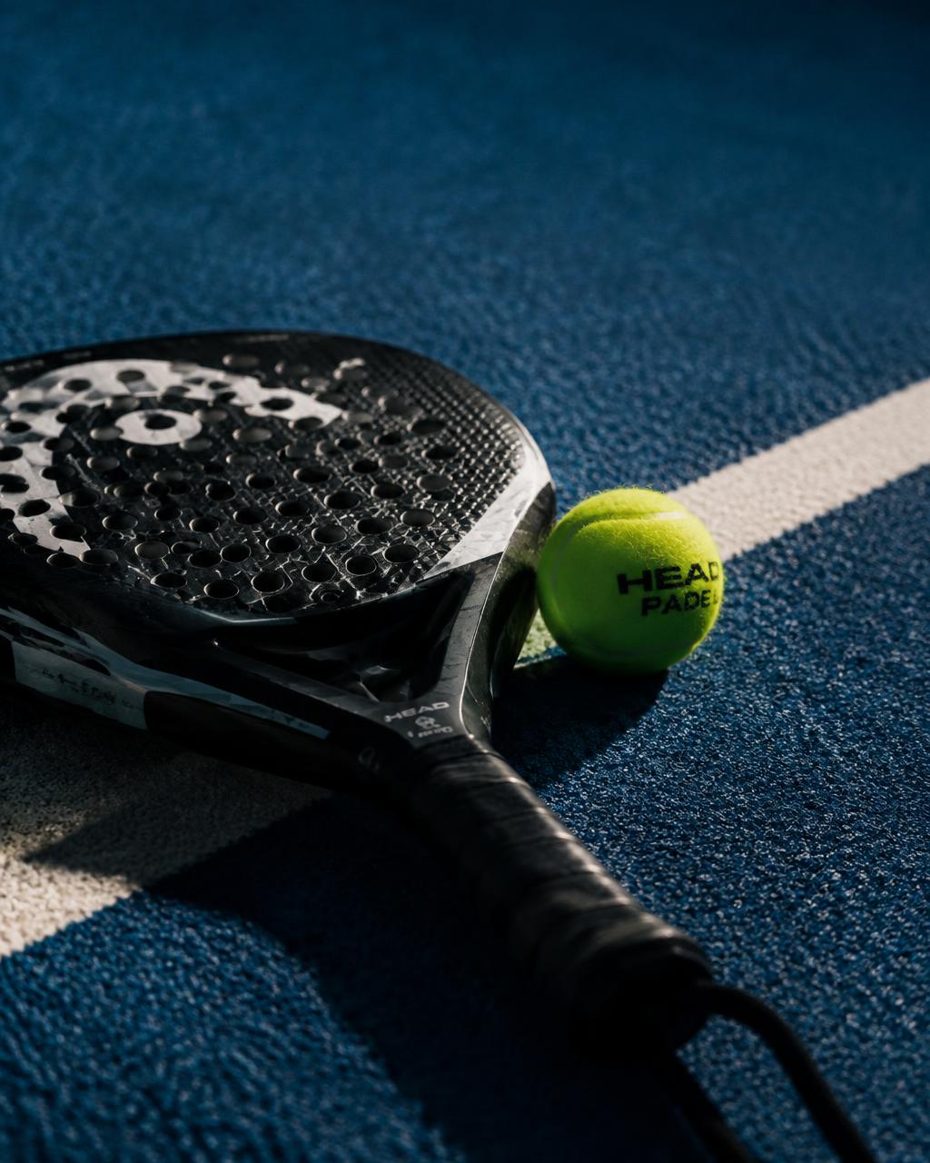 Padel ütő és labda a pályán